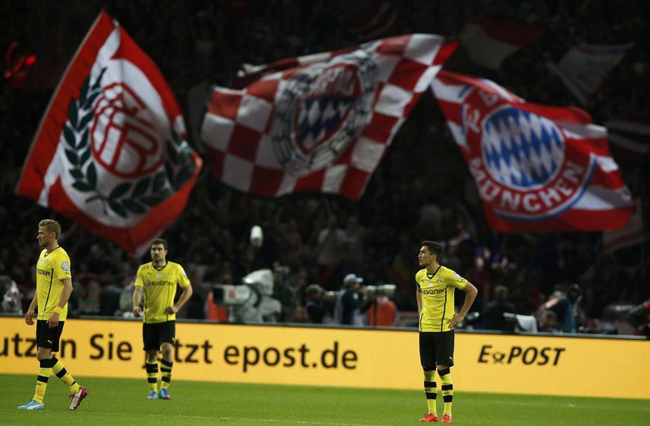 La delusione del Dortmund, mentre sullo sfondo sventolano le bandiere del Bayern. Action Images